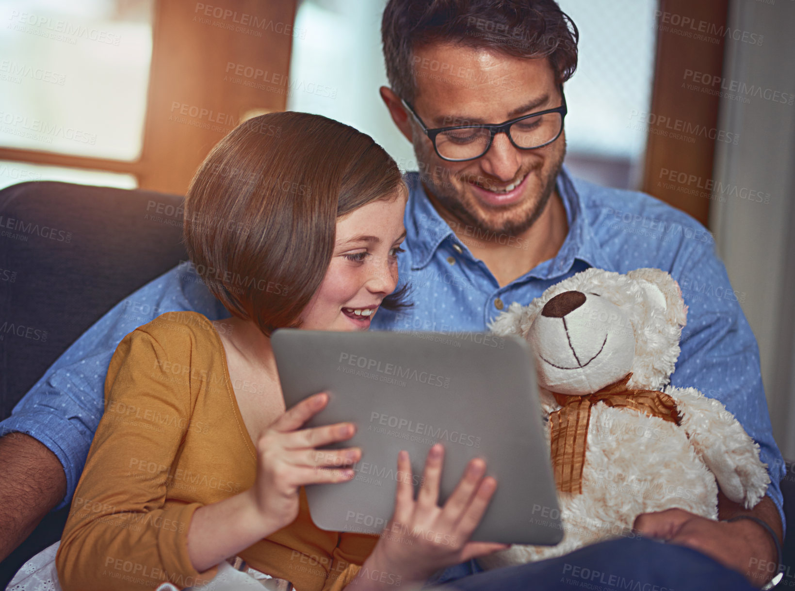 Buy stock photo Happy, man and child with tablet on sofa for internet connection, bonding and watching movie together. Home, father and daughter with teddy bear by tech for funny film, website and streaming service