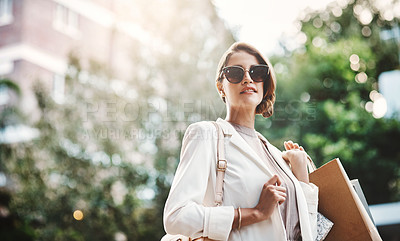 Buy stock photo Elegant woman holding shopping bags after a spending spree, retail therapy and buying clothes in a city. Trendy, stylish and fashionable lady purchasing gifts, presents and classy clothing downtown