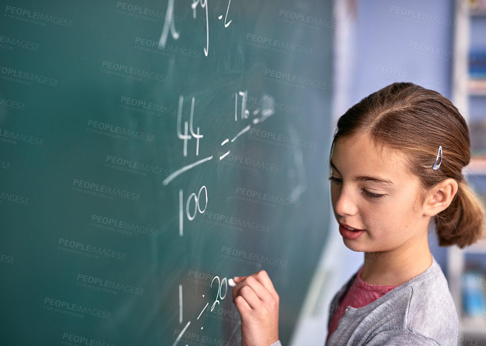 Buy stock photo Cropped shot of an elementary school girl writing on a blackboard in class