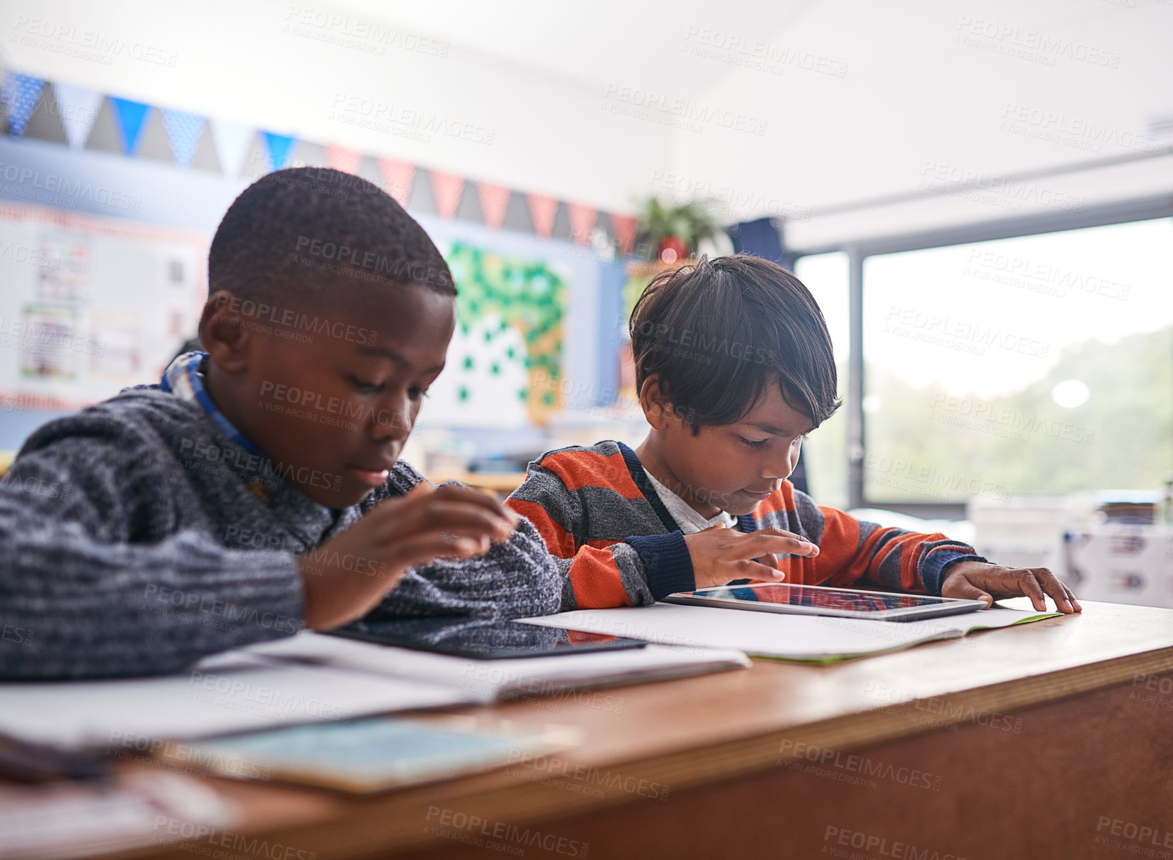 Buy stock photo Cropped shot of elementary school children using a tablet in class
