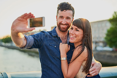 Buy stock photo Cropped shot of an affectionate young couple taking selfies while on a date