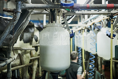 Buy stock photo Cropped shot of milk bottles being filled in a dairy