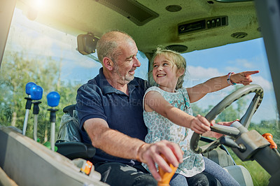 Buy stock photo Cropped shot of a male farmer and his daughter inside the cockpit of a modern tractor