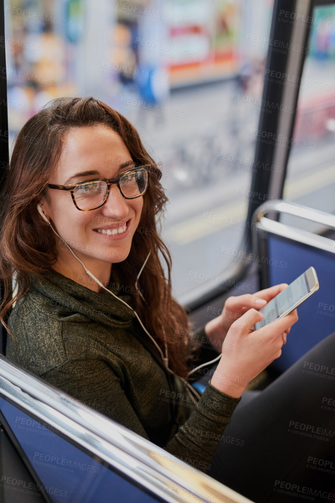 Buy stock photo High angle portrait of an attractive young woman listening to music while sitting on a bus