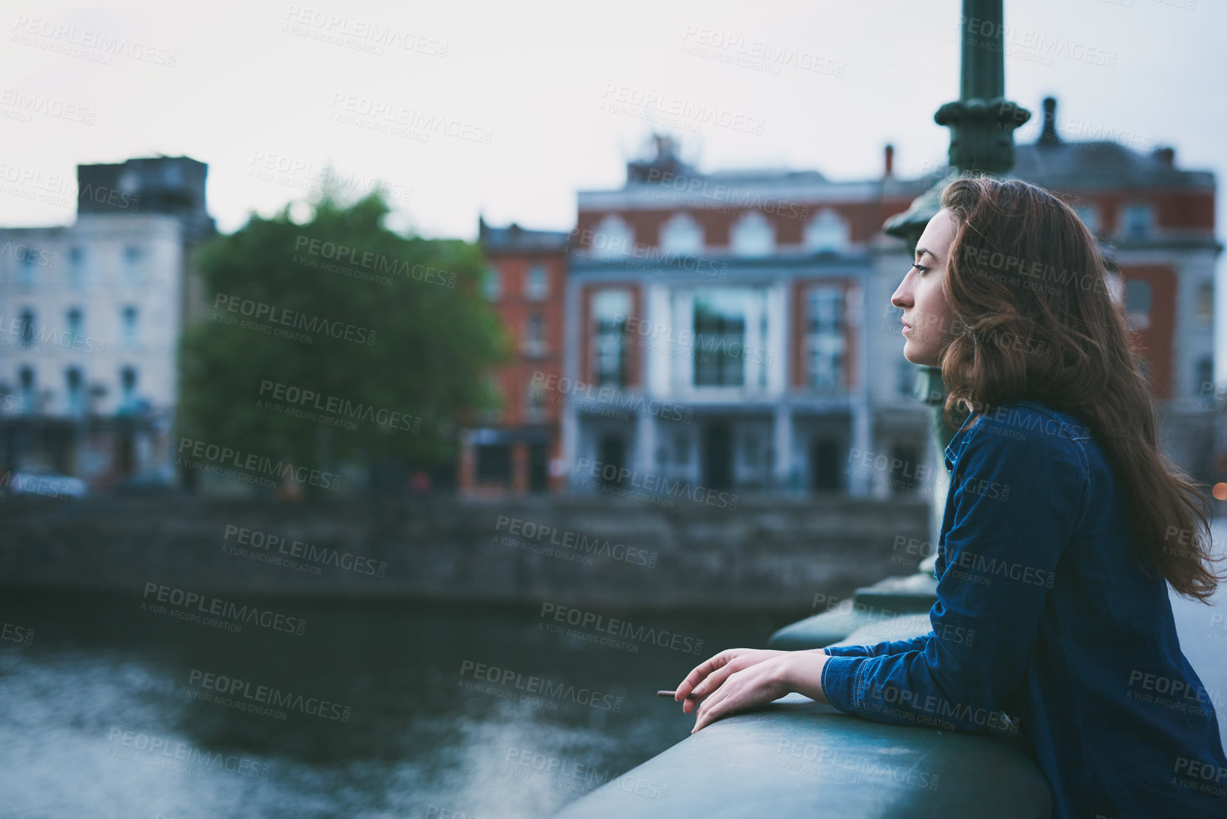 Buy stock photo Woman, cigarette and smoking on bridge in city with memory, depressed or sad by river on winter morning. Person, profile and reflection with tobacco product by water with mental health in Denmark