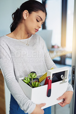 Buy stock photo Shot of an unhappy businesswoman holding her box of belongings after getting fired from her job