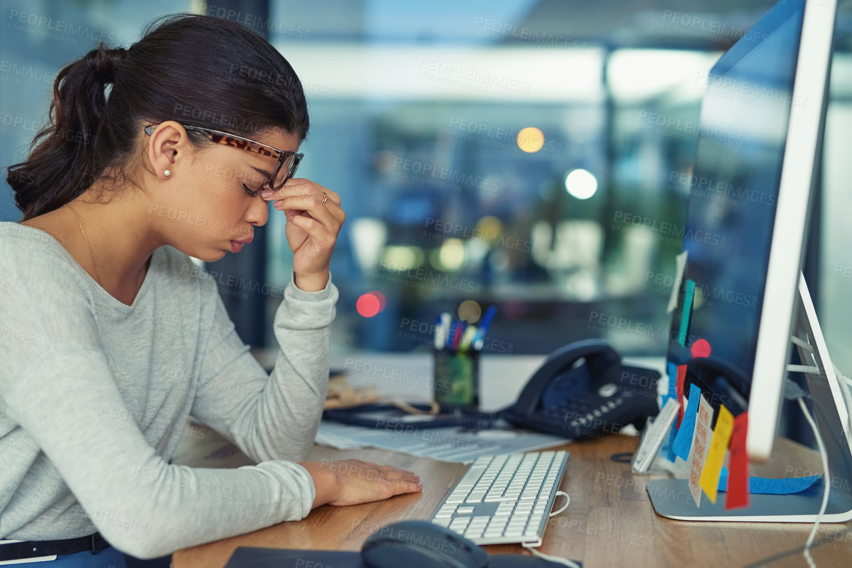 Buy stock photo Shot of a young businesswoman looking stressed out in an office