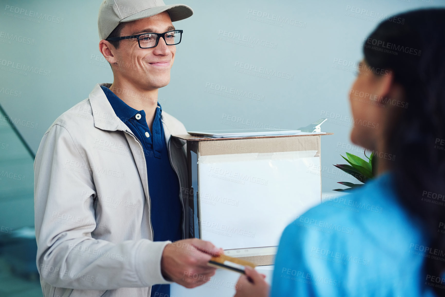 Buy stock photo Shot of a courier accepting a credit card payment from a customer for a delivery