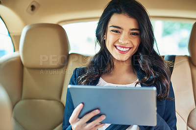Buy stock photo Shot of an attractive young woman using a tablet in a car