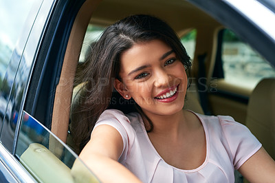 Buy stock photo Shot of an attractive young woman driving a car