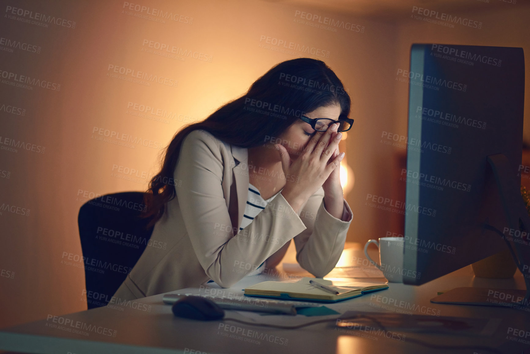 Buy stock photo Shot of a young businesswoman experiencing strain during a late night at work