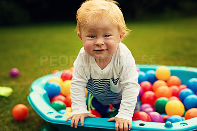 Buy stock photo Portrait, colourful and baby in backyard, ball pit and nature with fun, happiness and playful. Face, infant and toddler on grass, garden and carefree with peace, kid and childhood with game and smile