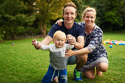 Buy stock photo Shot of an adorable little boy and his parents playing in the backyard