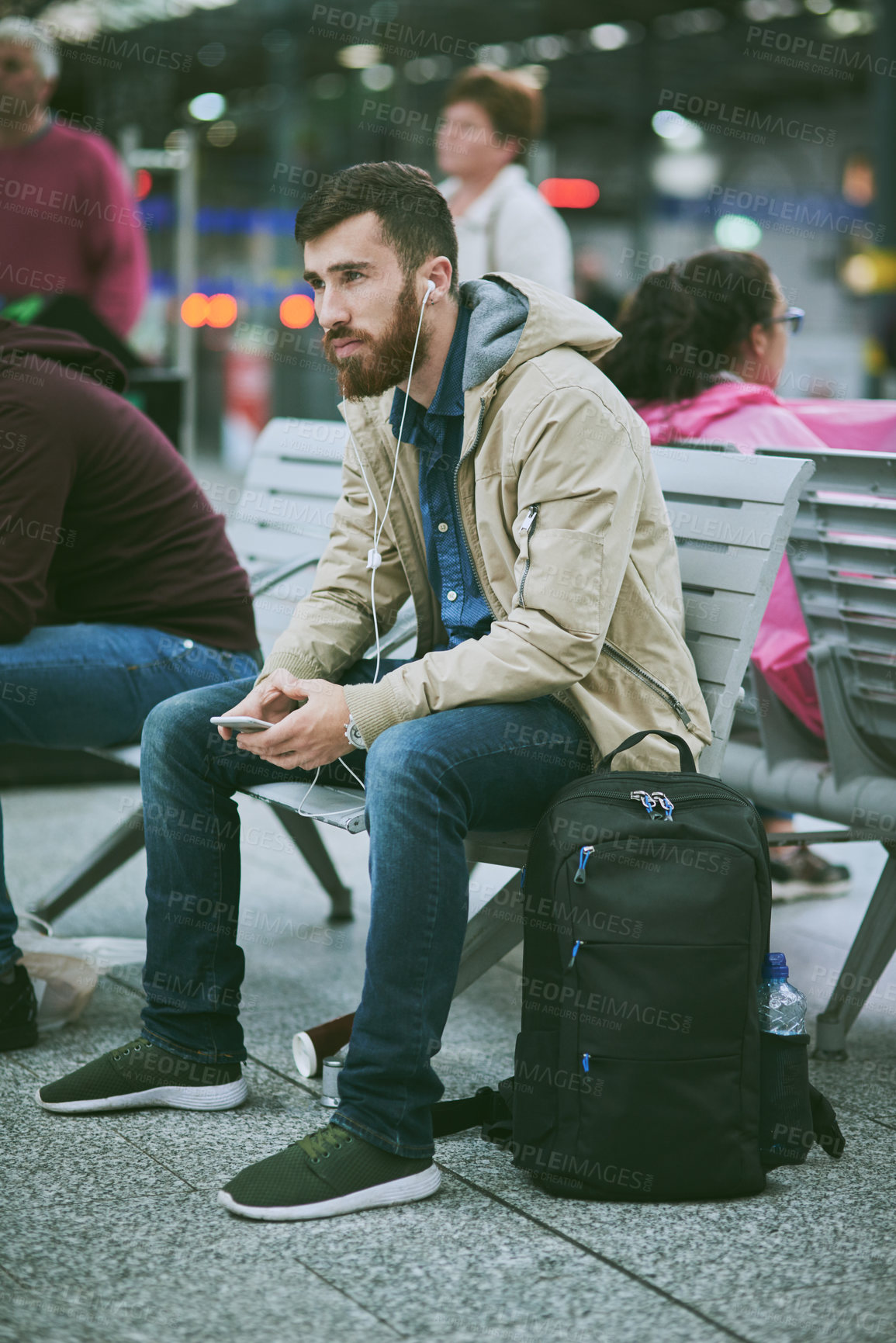 Buy stock photo Travel, earphones and man with phone at train station for music, streaming subscription and radio. Public transport, commute and person waiting on smartphone for listening to song, audio and podcast