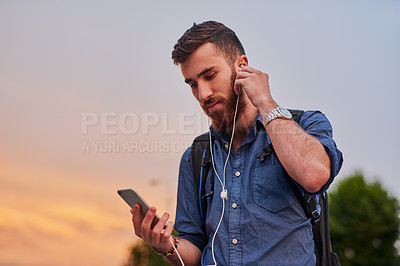 Buy stock photo Man, earphones and music in city for travel, social media and communication with smartphone or backpack. Artist, musician and streaming song for walking, podcast and creative inspiration with mobile