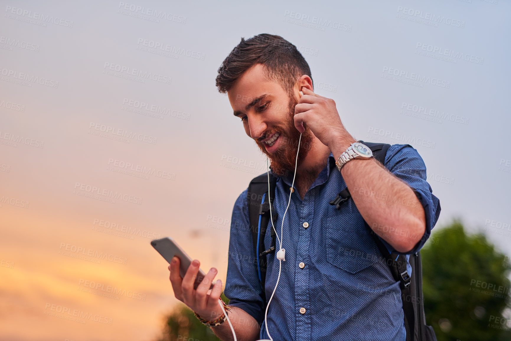 Buy stock photo Man, earphones and happy in city for walking, social media and communication with smartphone or backpack. Artist, musician and streaming music for travel, podcast and creative inspiration with mobile