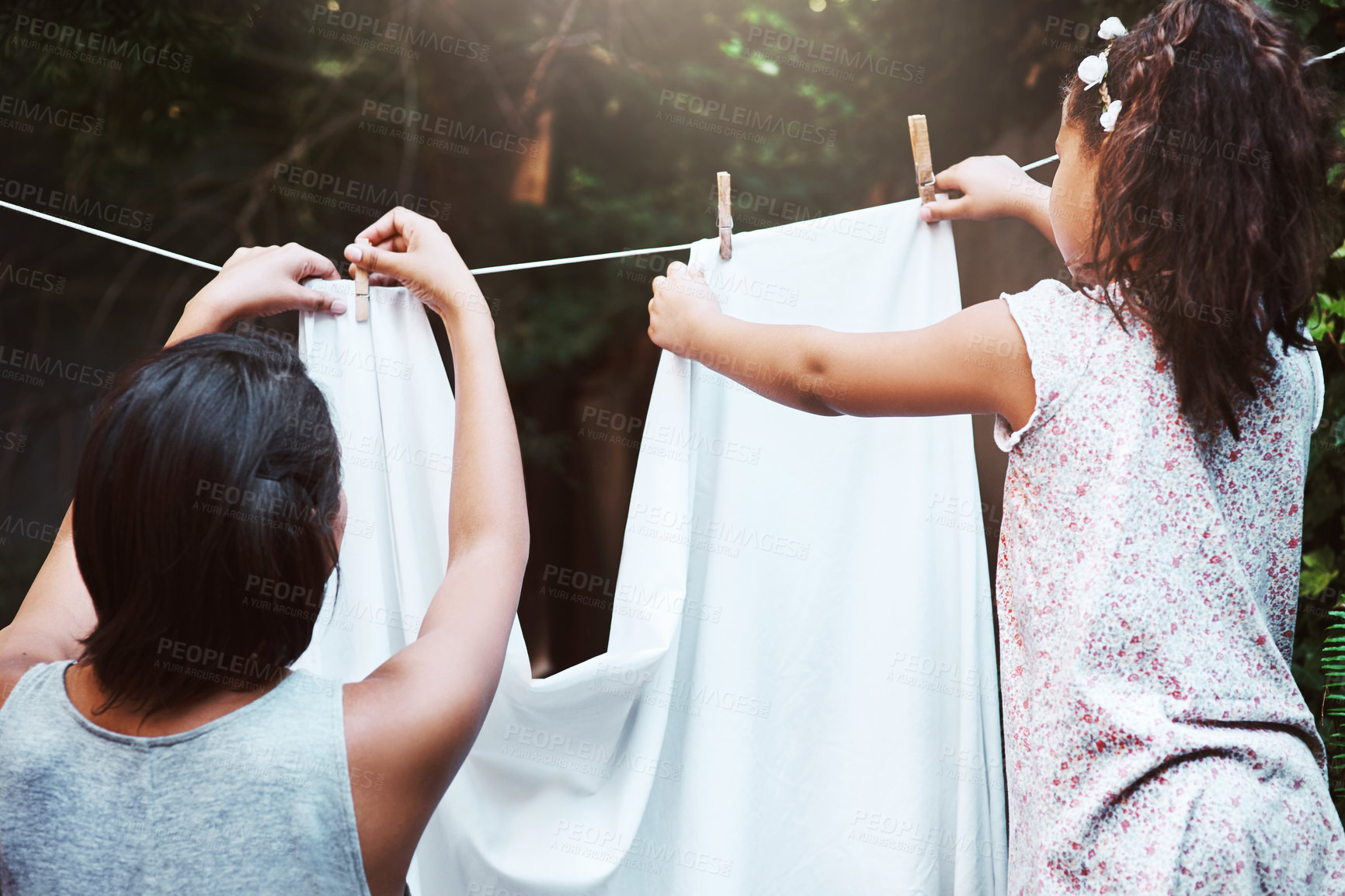 Buy stock photo Help, hanging laundry and a mother and child doing housework, chores and busy with clothes. Cleaning, family and back of a little girl helping mom with clothing on the line in the backyard together