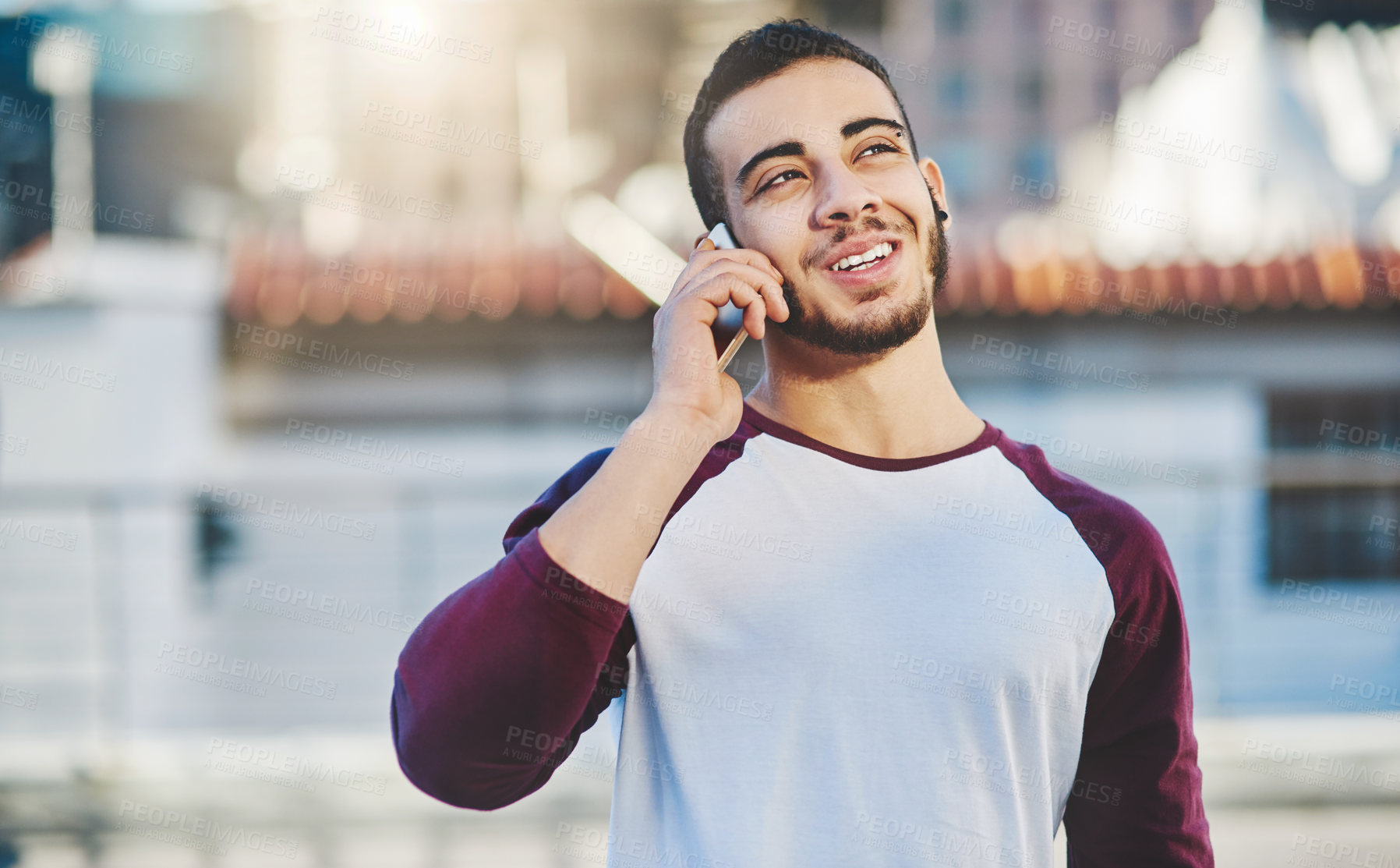 Buy stock photo Cropped shot of a handsome young man making a phone call while standing outside