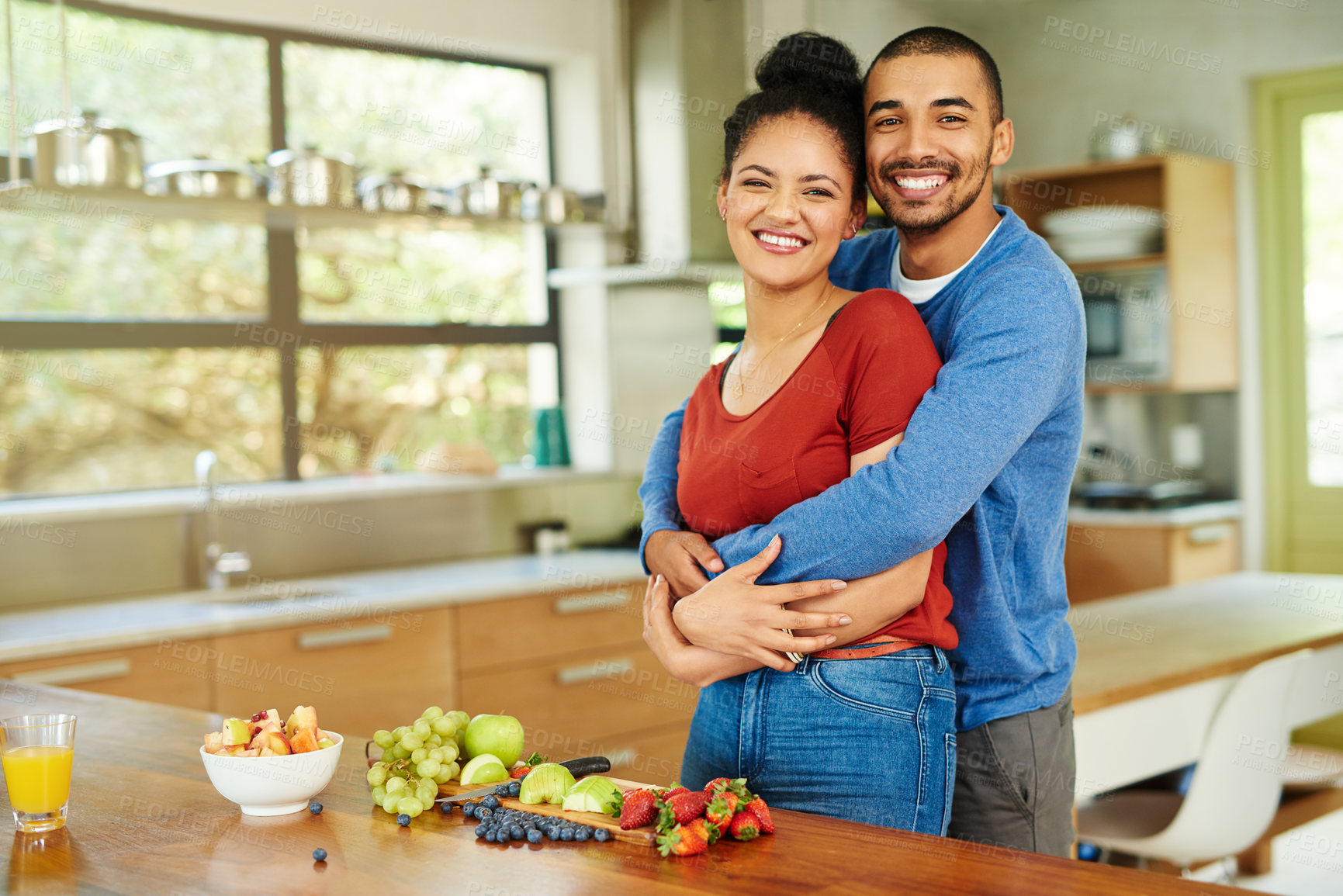 Buy stock photo Portrait, kitchen and couple with fruit, hug and smile with romance, relationship and bonding together. House, embrace or man with woman, breakfast, love and care with trust or marriage with wellness