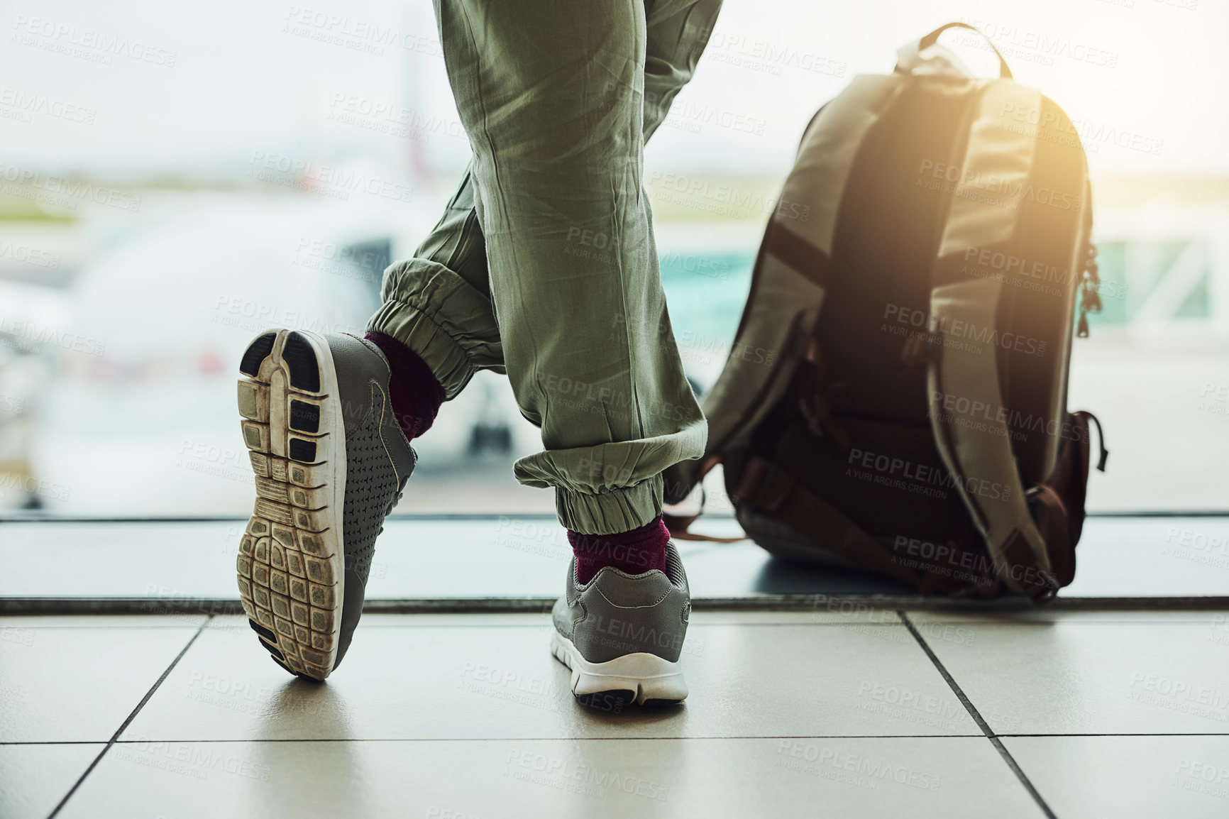 Buy stock photo Shoes, person and waiting at airport window with travel backpack, flight delay and terminal schedule. Sneakers, passenger and relax with luggage bag for transport, holiday and Global opportunity 