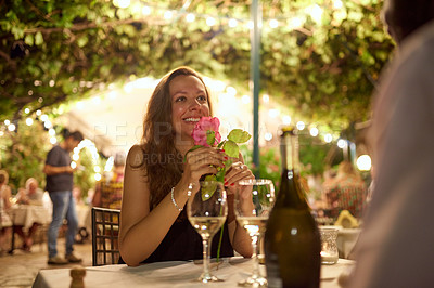 Buy stock photo Shot of a woman receiving a rose from her date while at a restaurant