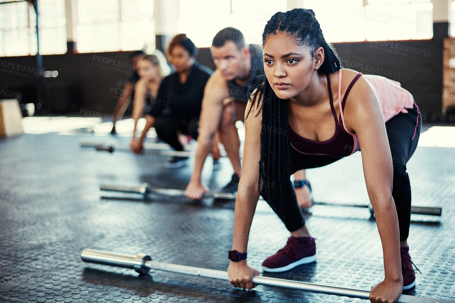 Buy stock photo Shot of a fitness group using steel bars in their session at the gym