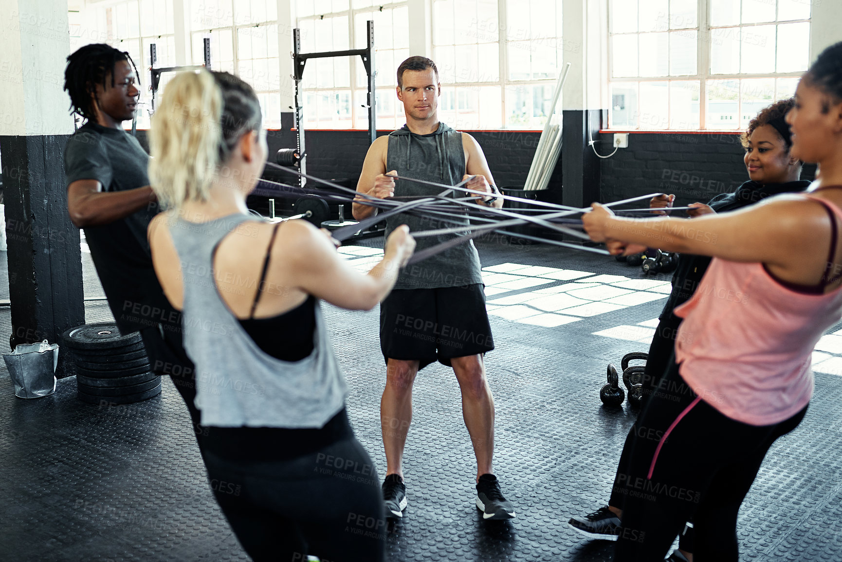 Buy stock photo Shot of a fitness group working out with resistance bands in their session at the gym