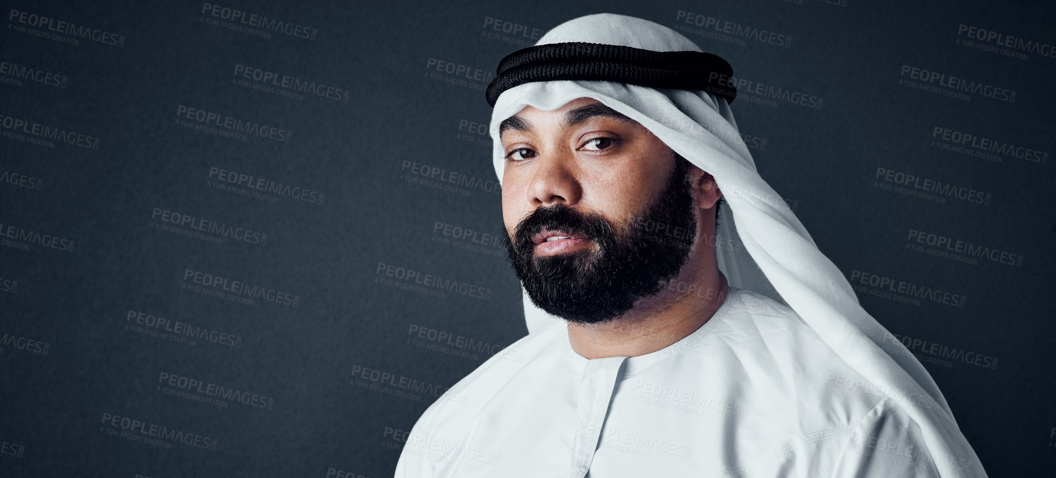 Buy stock photo Studio shot of a young man dressed in Islamic traditional clothing posing against a dark background