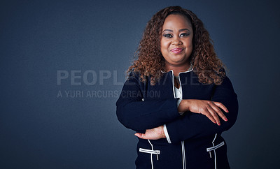 Buy stock photo Portrait of a cheerful young businesswoman standing with her arms folded while standing against a blue background