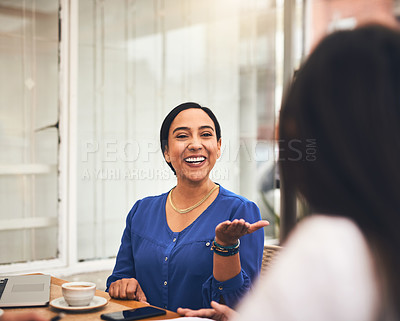 Buy stock photo Shot of a cheerful young creative businesswoman having a discussion with coworkers at a meeting around a table in a coffeeshop