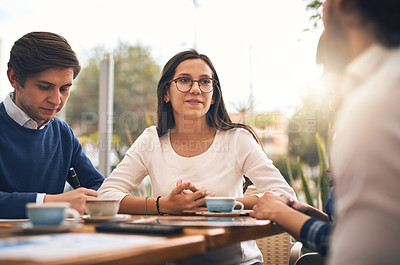 Buy stock photo Shot of a group of creative businesspeople having a meeting around a table outside of a coffeeshop