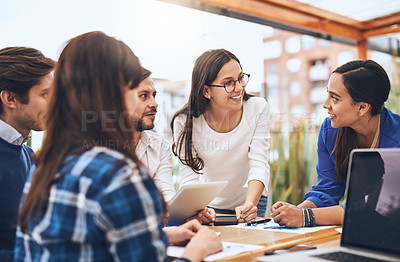 Buy stock photo Shot of a group young creative businesspeople working together around a table outside of a coffeeshop