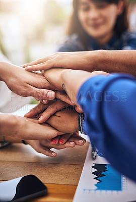 Buy stock photo Cropped shot of a group of unrecognisable people's hands forming a huddle together around a table outside