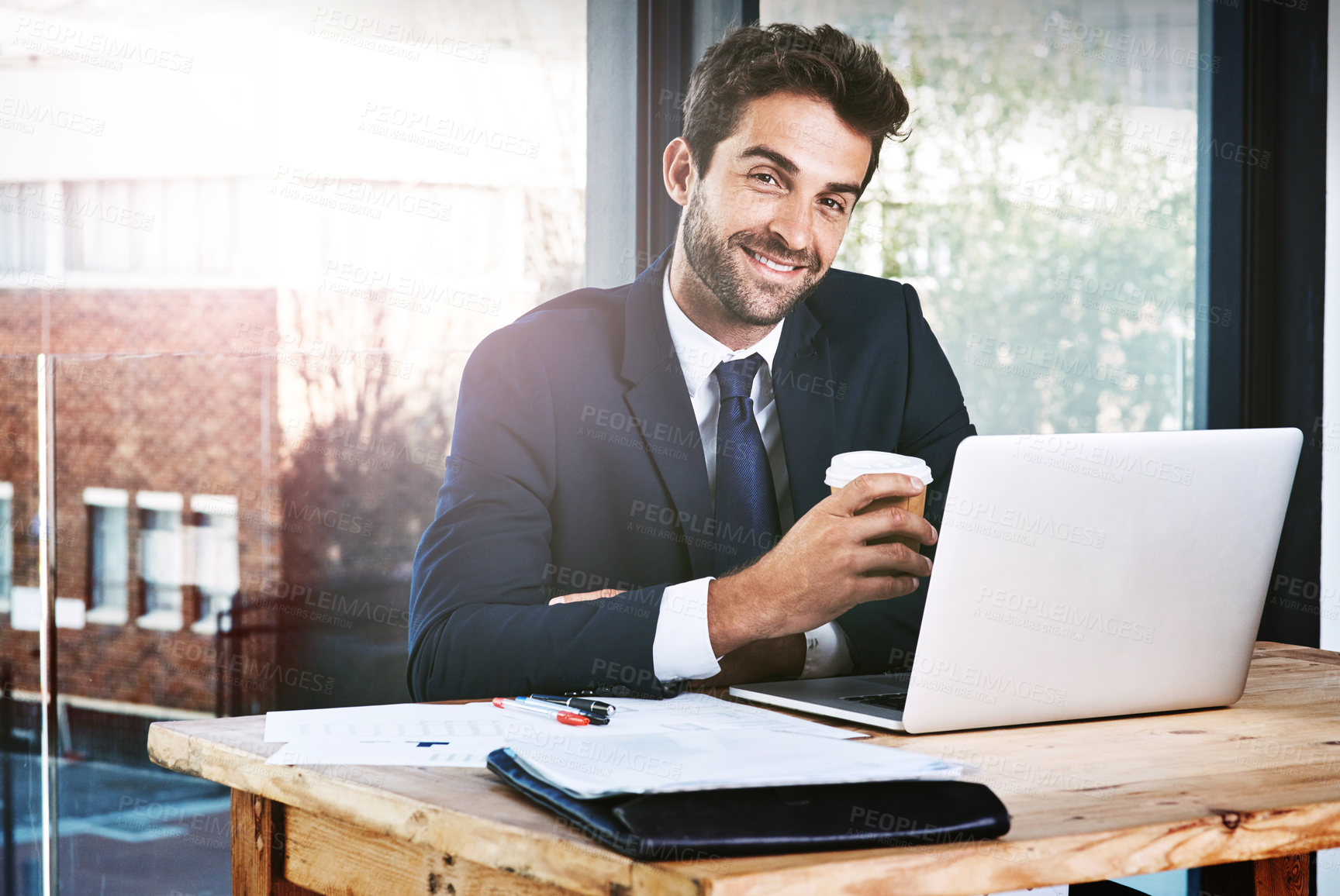 Buy stock photo Cropped portrait of a handsome young businessman working on his laptop in the office