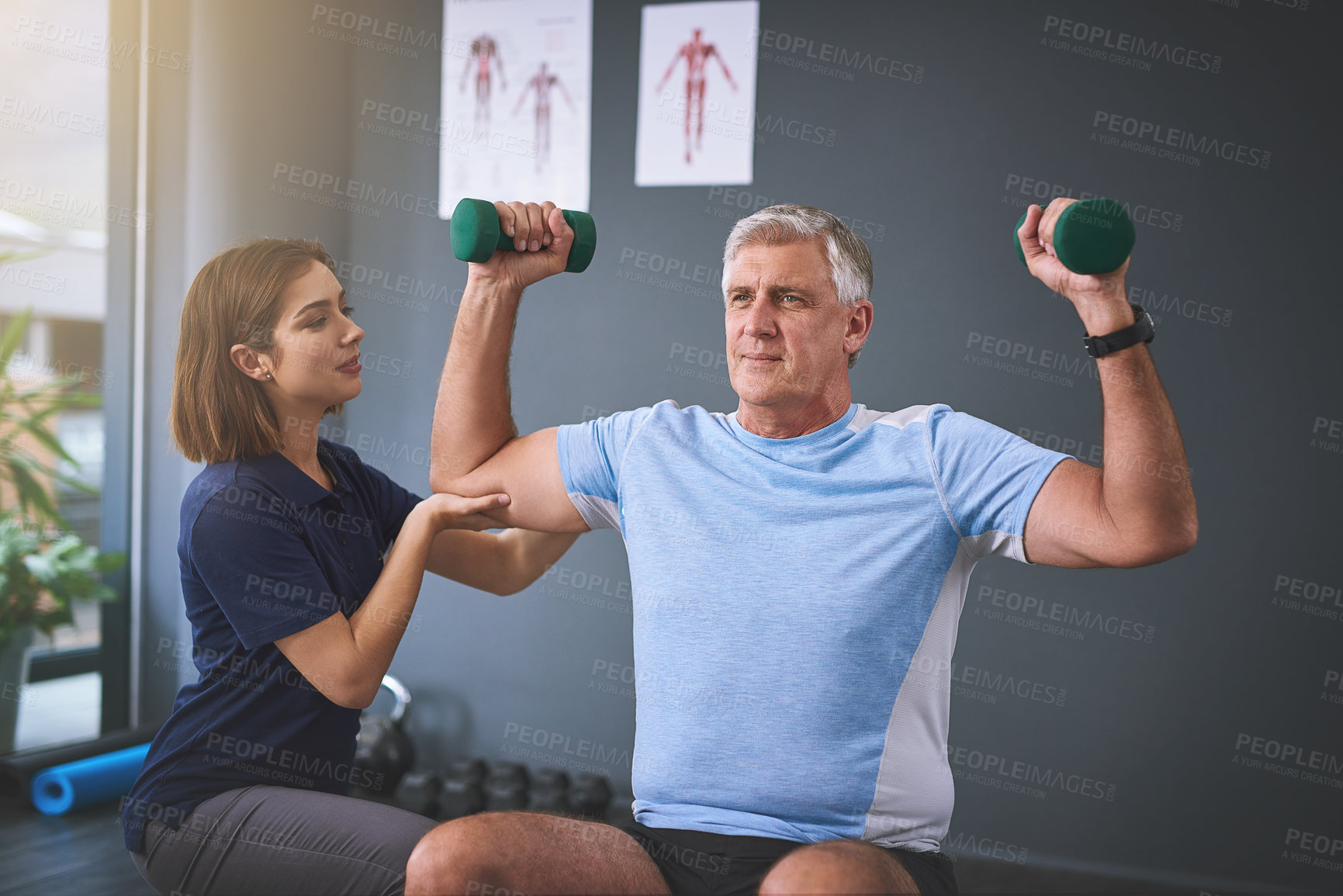 Buy stock photo Mature man, dumbbells and physiotherapy help at clinic, rehabilitation and muscle training care. Physical therapy, woman and patient support of medical wellness, anatomy recovery or mobility progress