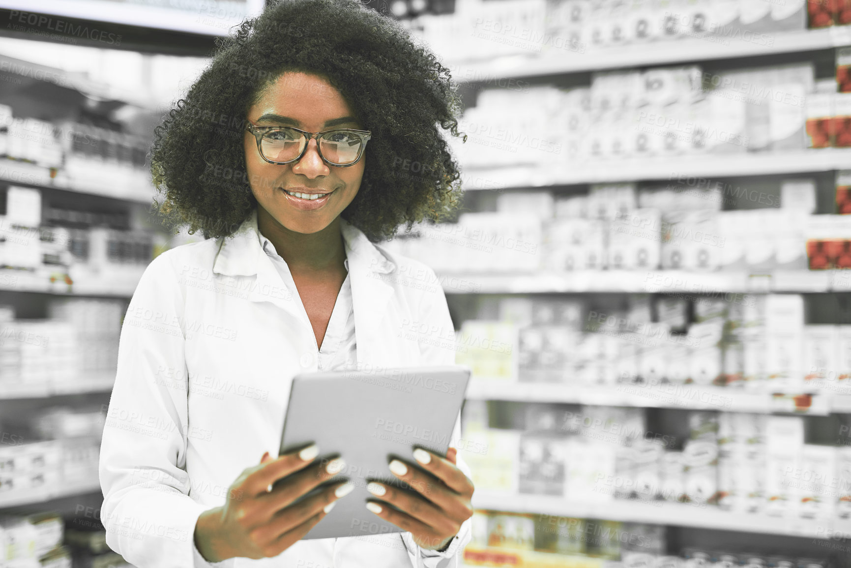 Buy stock photo Portrait of a cheerful young female pharmacist standing with a digital tablet while looking at the camera in a pharmacy