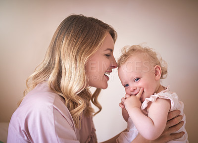 Buy stock photo Shot of a young woman bonding with her baby girl at home