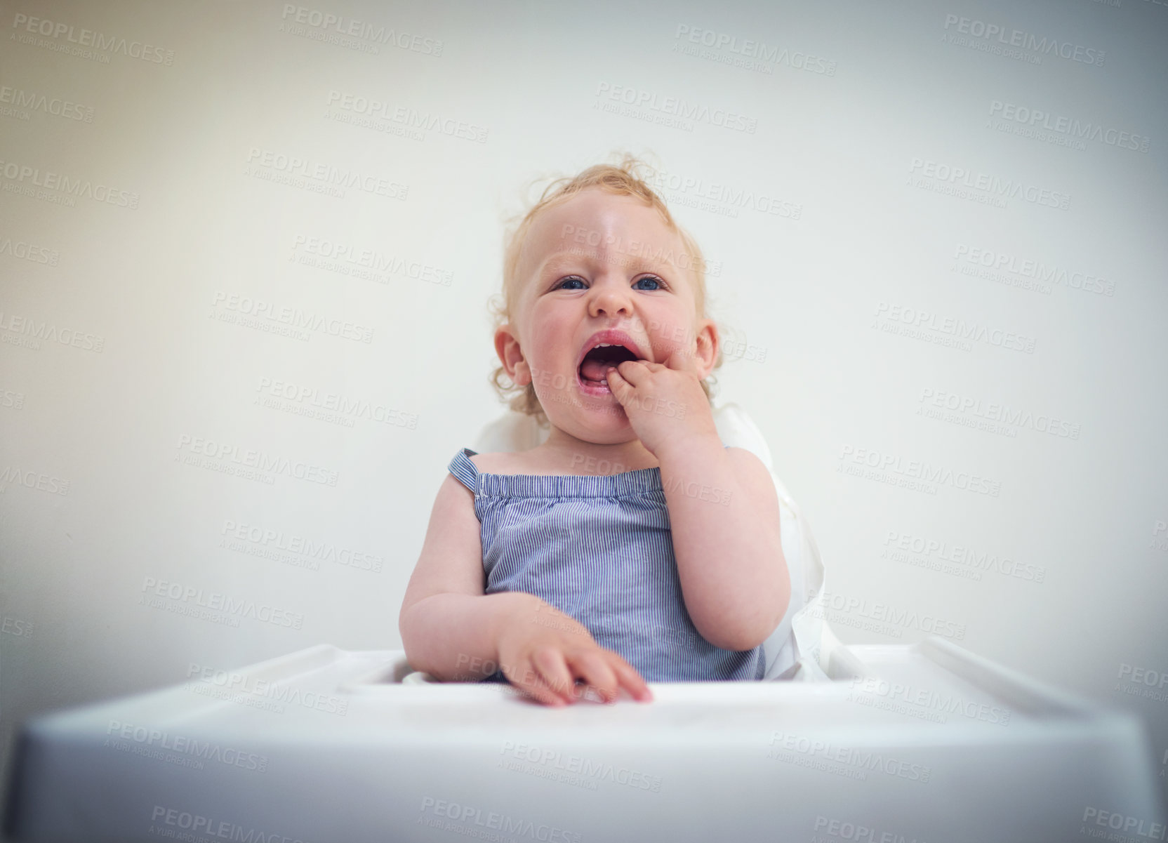 Buy stock photo Shot of an adorable baby girl sitting in her high chair at home