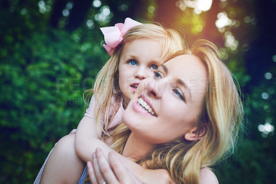 Buy stock photo Shot of an adorable little girl bonding with her mother during a day outdoors