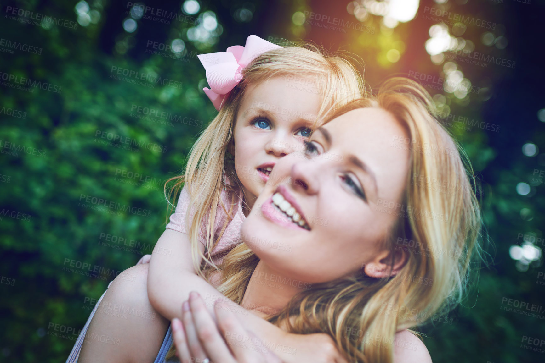 Buy stock photo Shot of an adorable little girl bonding with her mother during a day outdoors