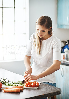 Buy stock photo Cropped shot of a young woman preparing a healthy meal at home