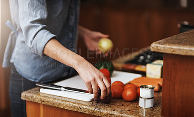 Buy stock photo Closeup shot of a young woman chopping vegetables in the kitchen