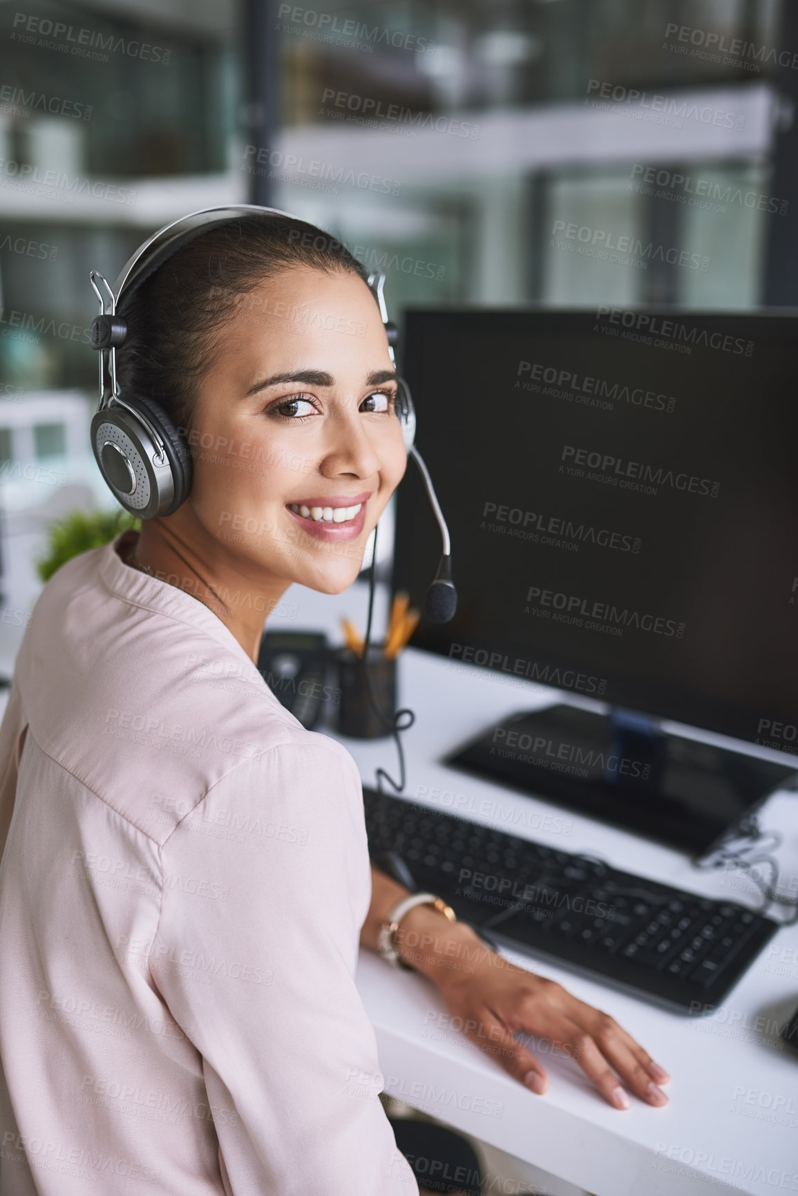 Buy stock photo Portrait of a cheerful businesswoman talking to a customer using a headset while looking at the camera