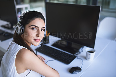 Buy stock photo Portrait of a cheerful businesswoman talking to a customer using a headset while looking at the camera