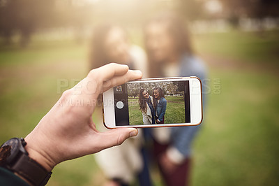 Buy stock photo Shot of two cheerful young friends taking a self portrait together outside in a park