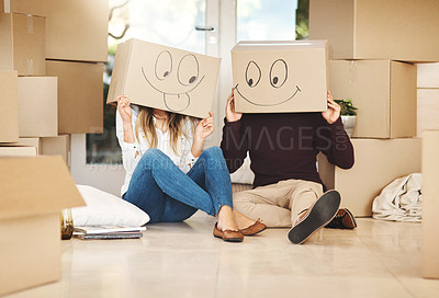 Buy stock photo Moving, couple and cardboard box with smiley face in new home for real estate, mortgage or property investment. Emoji, homeowner and excited man with woman for packing, fresh start or relocating