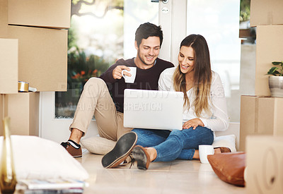 Buy stock photo Full length shot of a young couple using a laptop while moving into a new home