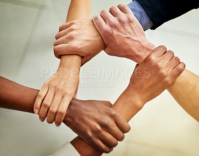 Buy stock photo Cropped shot of a group of businesspeople linking their arms in solidarity