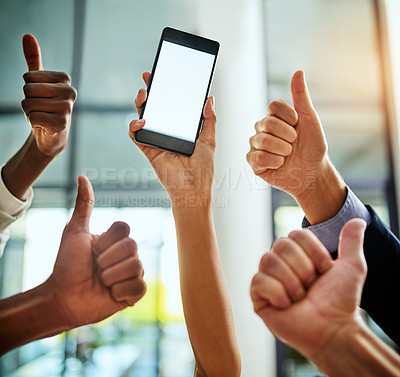 Buy stock photo Cropped shot of a group of businesspeople giving thumbs up and holding a mobile phone in a modern office