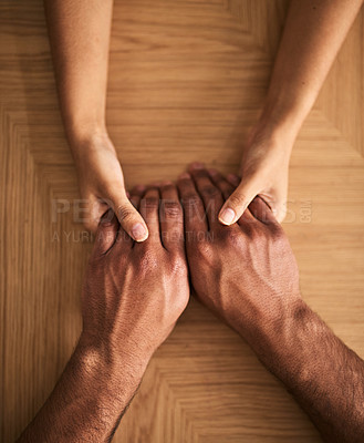 Buy stock photo Man and woman holding hands sharing feelings of love, support and trust together on a table. Closeup of a loving couple expressing care, promise and compassion to overcome problems 